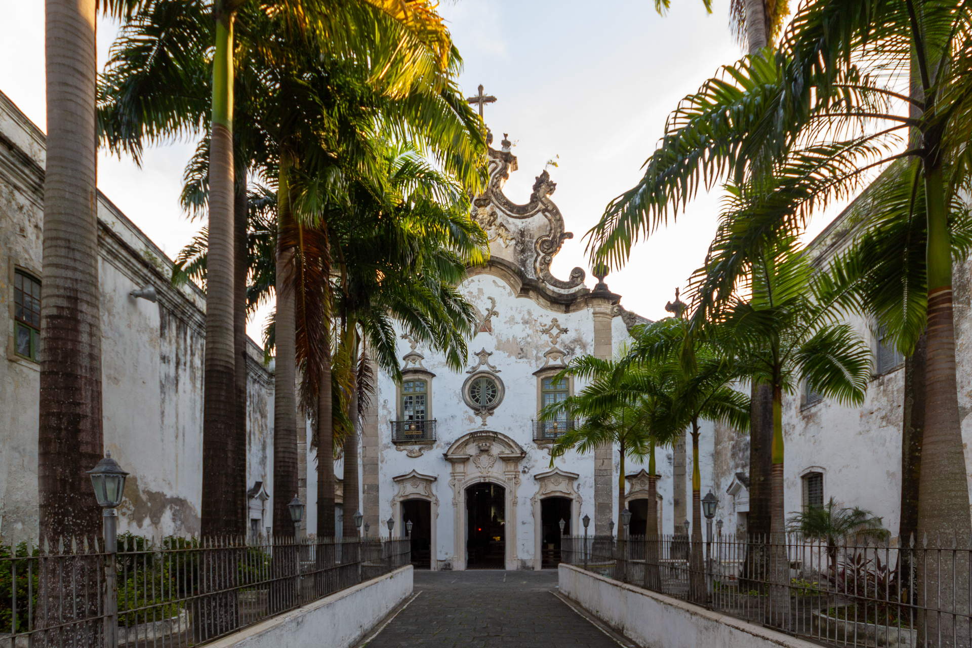 fachada da Terceira Ordem Igreja de Santa Teresa do Menino Jesus do Recife, a frente há diversas palmeiras em duas filas compondo o seu jardim de entrada.
